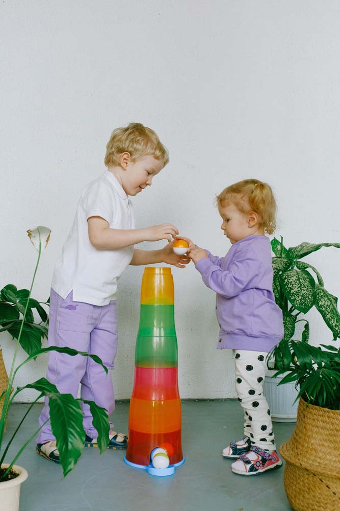 Siblings sharing with their toys