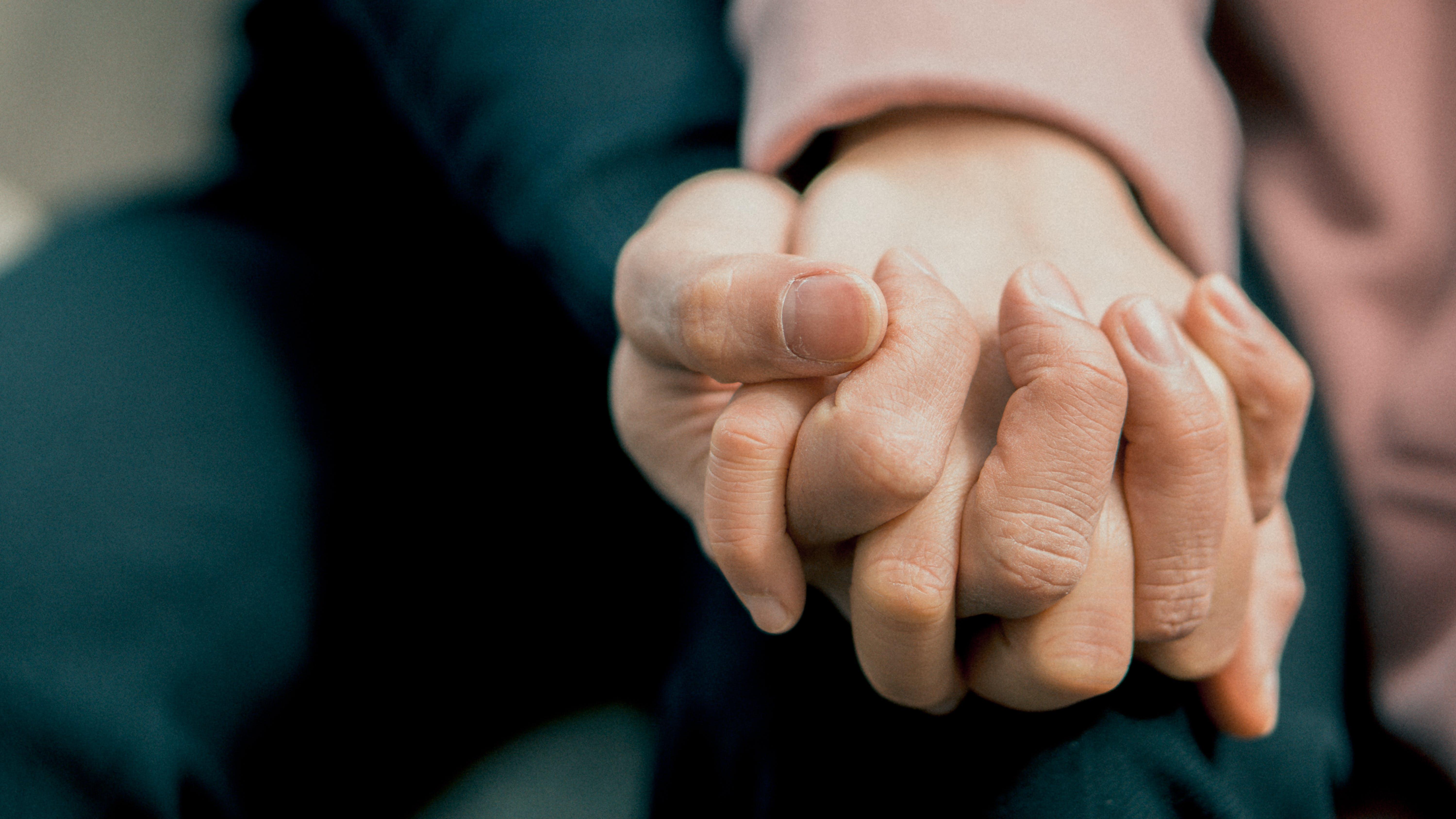 two people linking hands supporting each other
