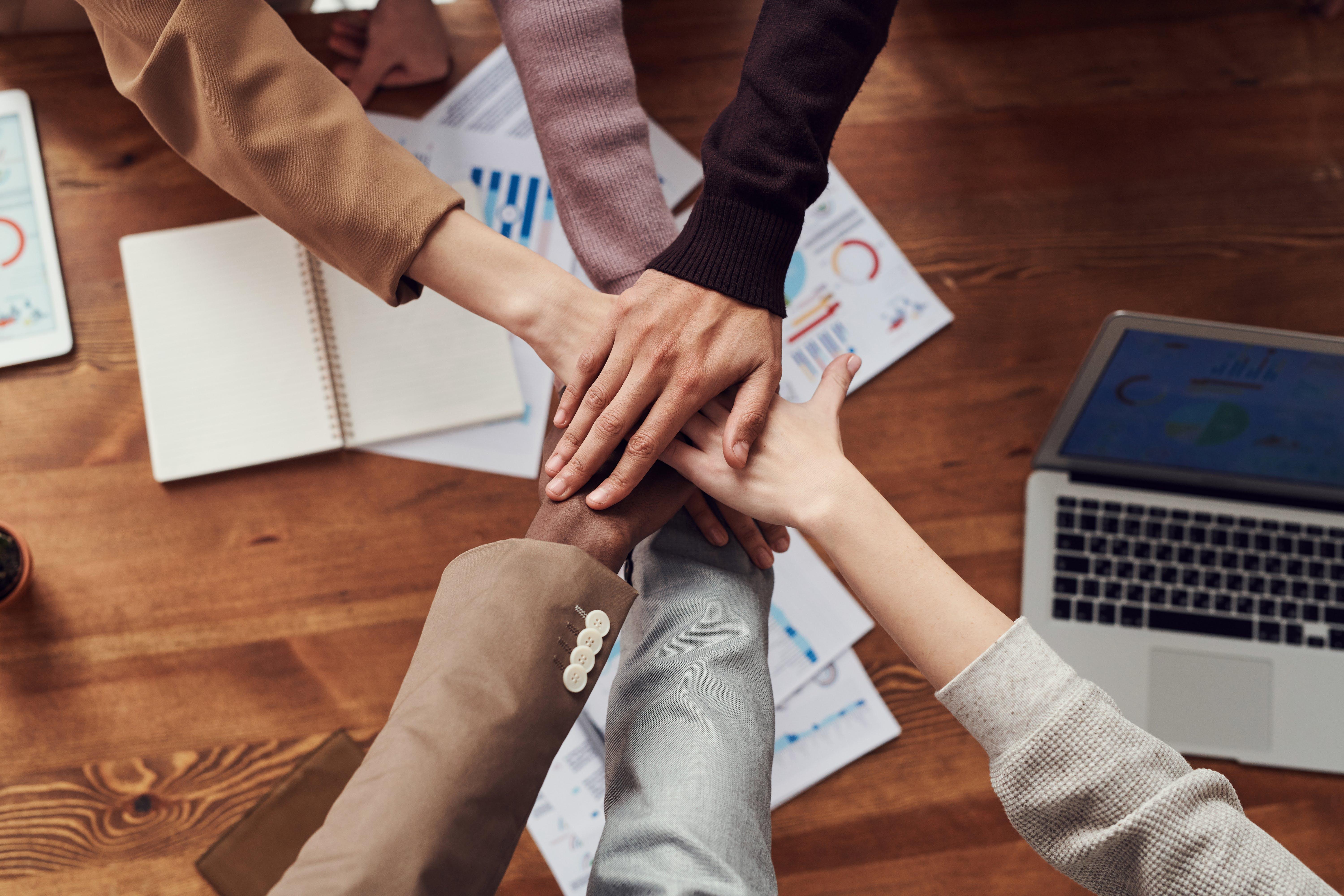 team working together with hands in the middle